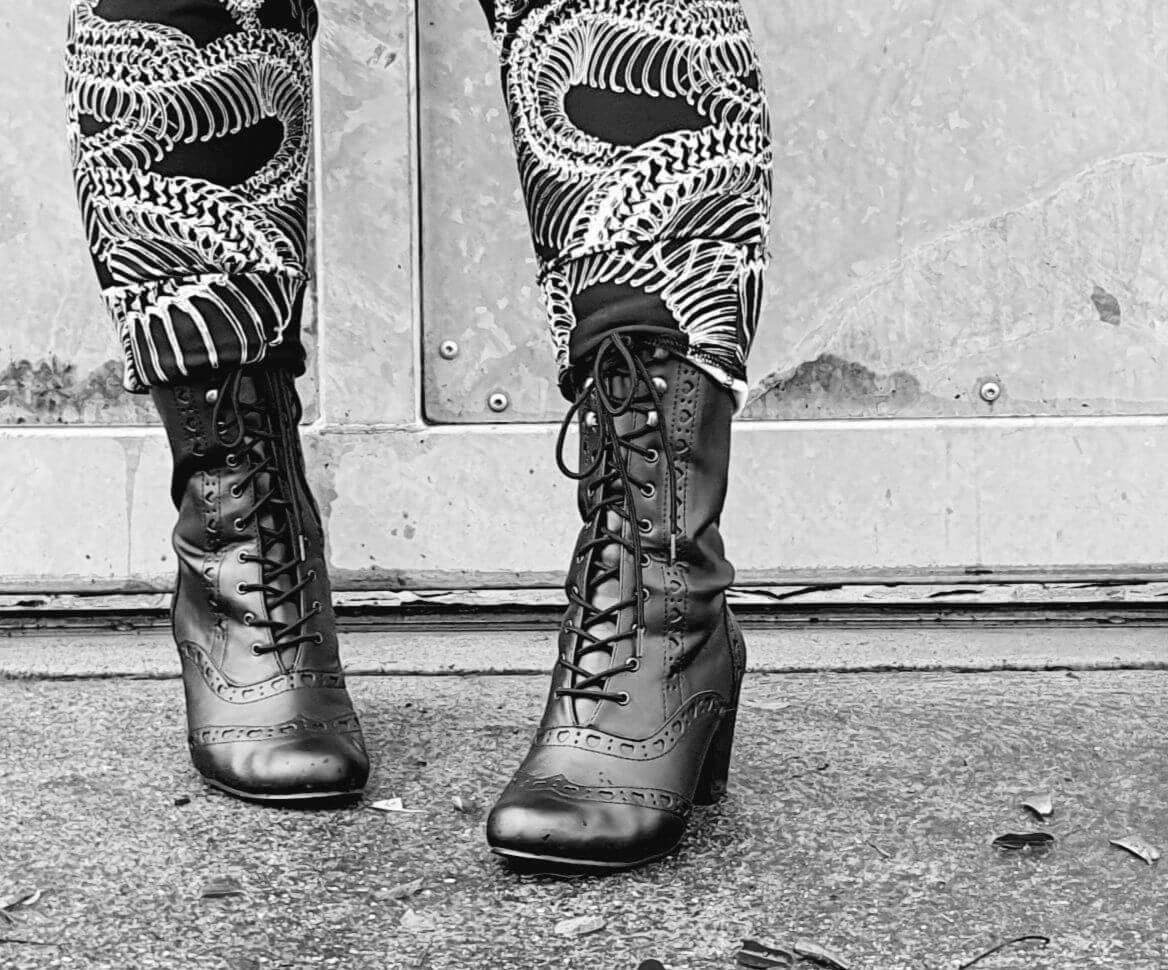 Vivika 200 stylish black lace-up shoes paired with unique patterned pants, perfect for festivals and pole dance.