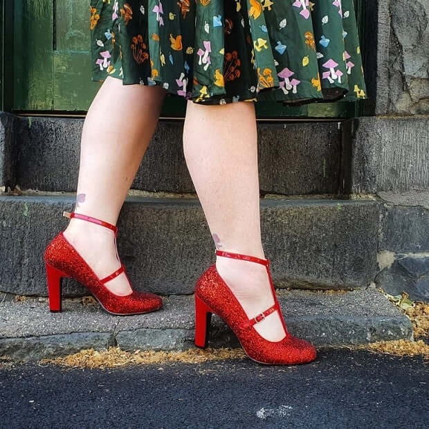 Festive Footwear featuring sparkling red high heels paired with a colorful floral skirt.