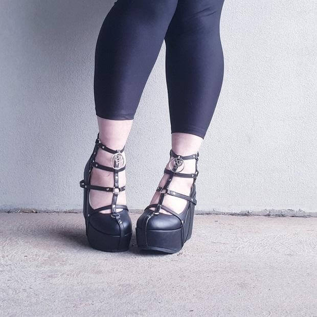 A pair of stylish black heels with straps, perfect for alternative fashion and festivals, showcasing the Poison aesthetic.